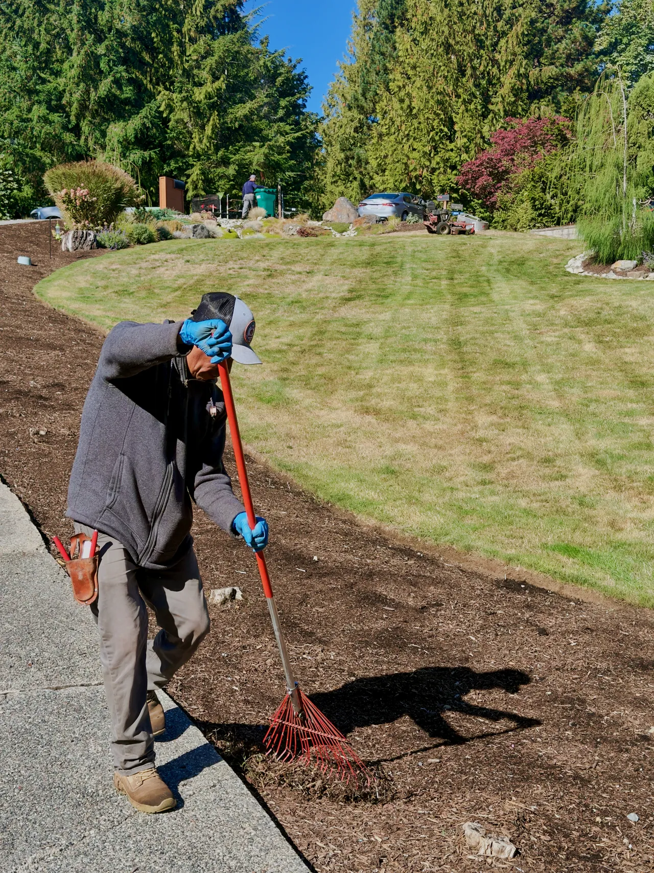 Angel, heavy equipment and hardscape specialist, raking new topsoil level