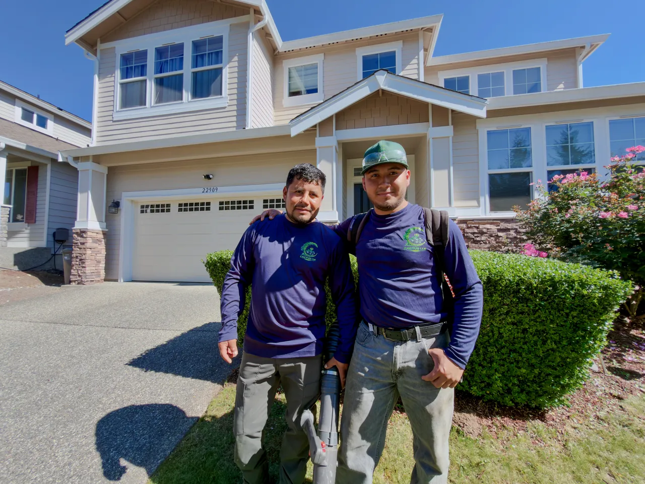 Two crew members with equipment on the drive, front beds finished