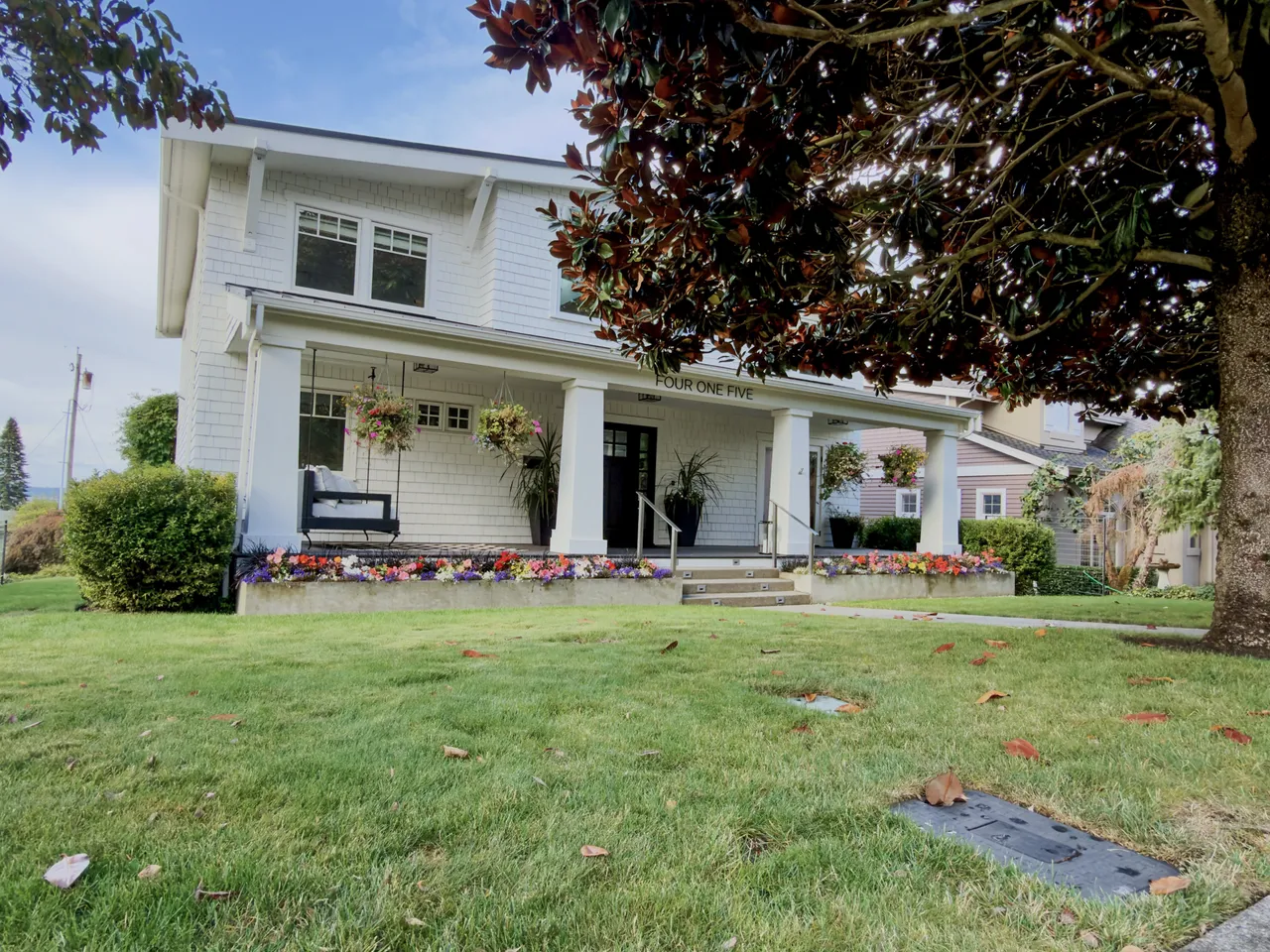 White craftsman porch and lawn in soft autumn light